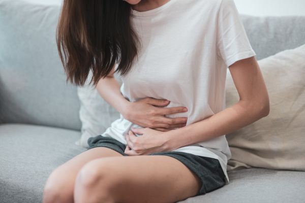 お腹をおさえる女性